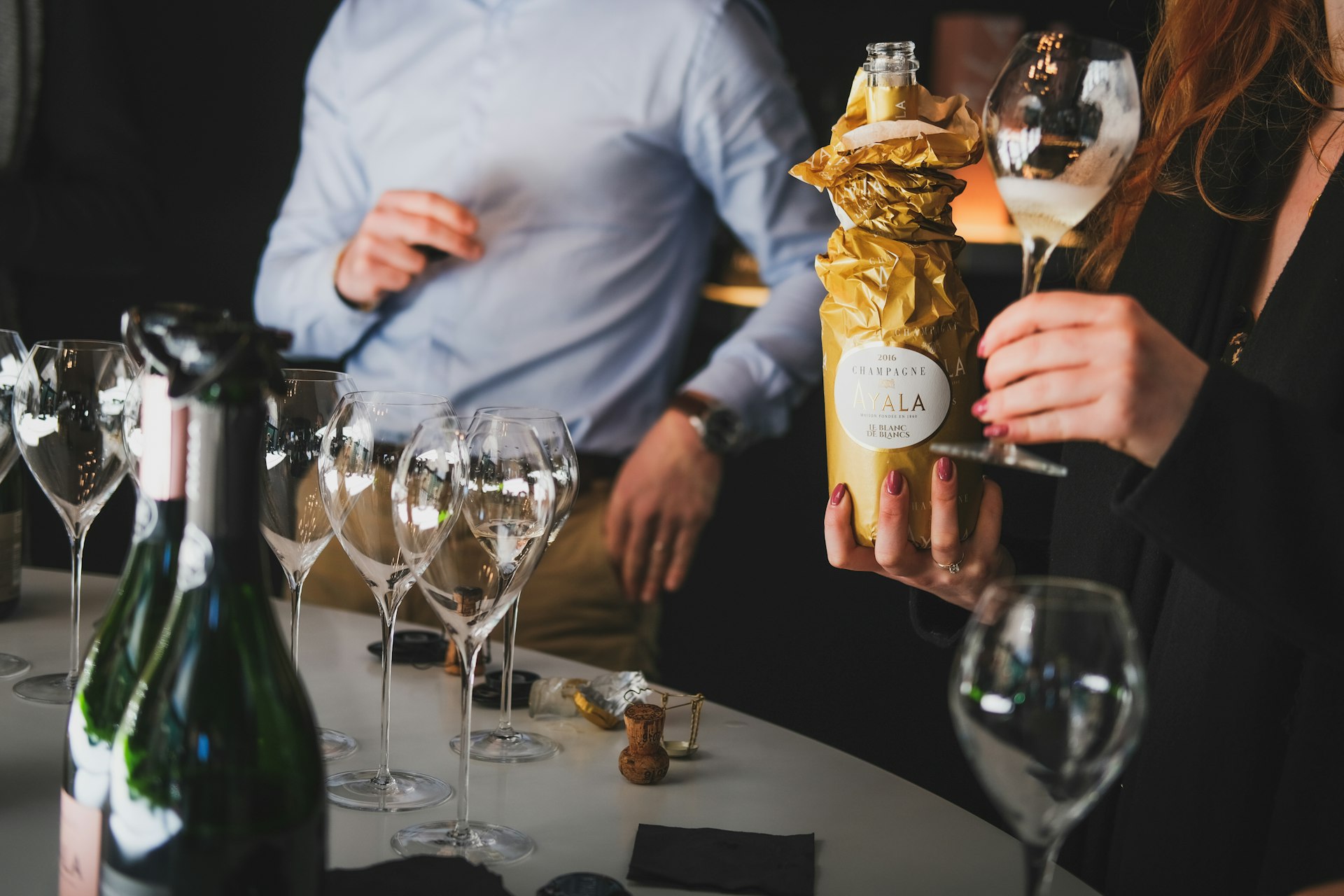 a group of people standing around a table with wine glasses